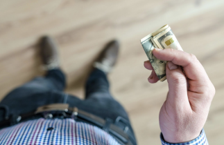 Man Standing and Holding a Handful of Money